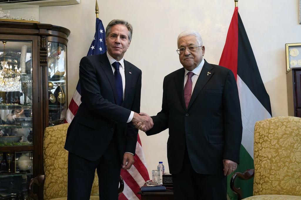 U.S. Secretary of State Antony Blinken, left, shake hands with Palestinian President Mahmoud Abbas, in Amman, Jordan