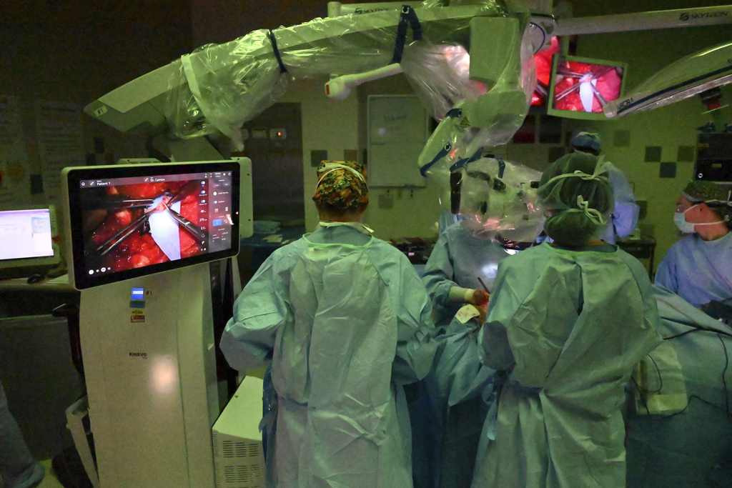 The surgical team, using an operative microscope, performs microvascular anastomosis during Rudy Noorlander