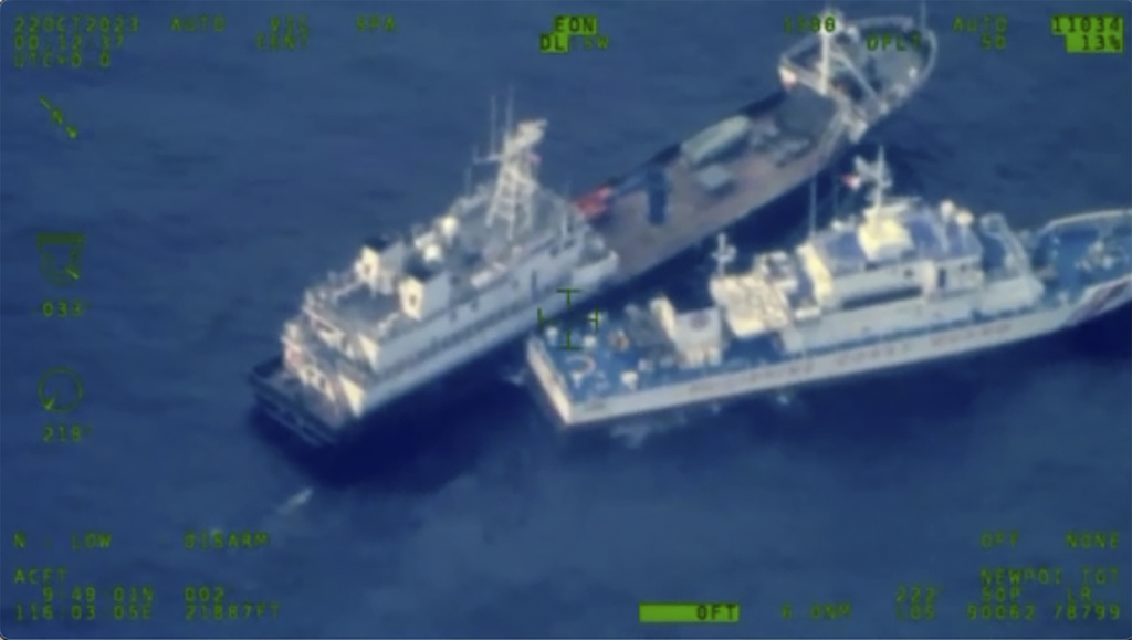 A Chinese militia vessel, top, near Philippine coast guard vessel BRP Cabra as they approach Second Thomas Shoal