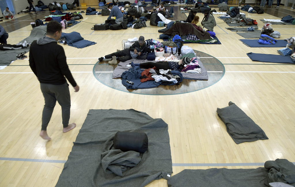 Migrants rest at a makeshift shelter in Denver