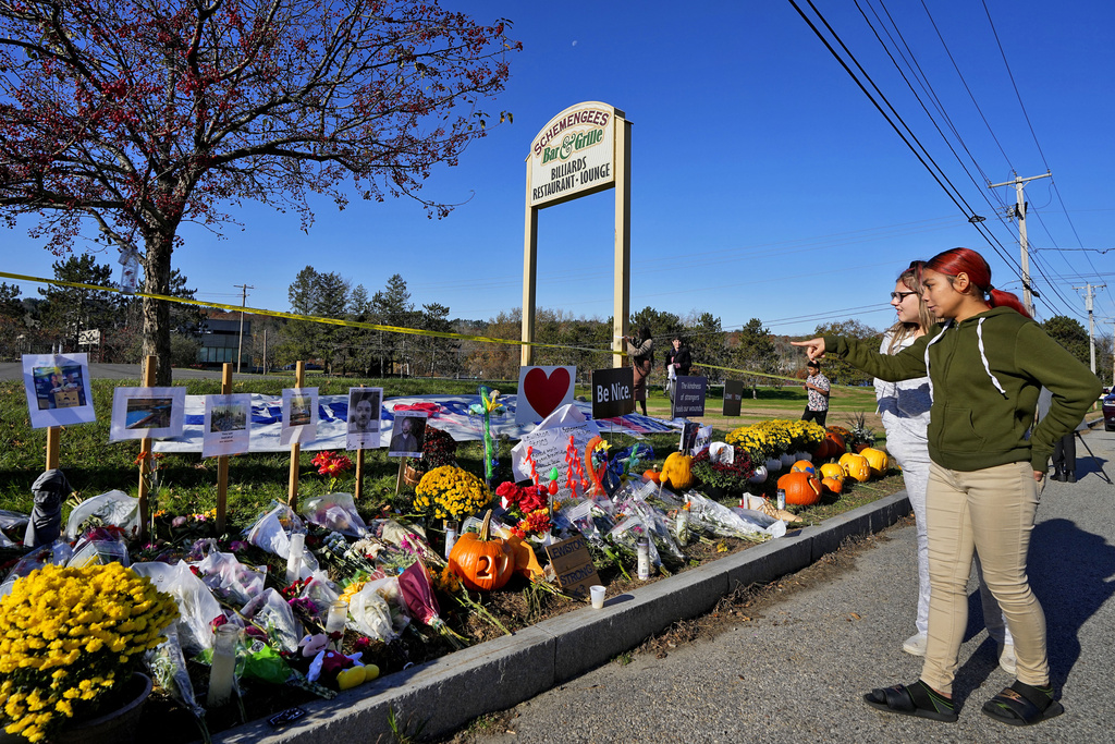 Community members look at a memorial outside Schemengees Bar & Grille