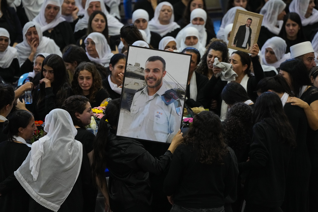 Mourners gather around the flag draped coffin of Druze Israeli Lieutenant colonel Salman Habaka in the village of Yanuh Jat, northern Israel