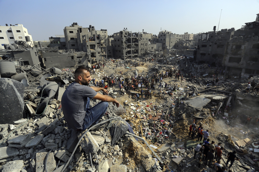 A man sits on the rubble overlooking the debris of buildings that were targeted by Israeli airstrikes in the Jabaliya refugee camp, northern Gaza Strip