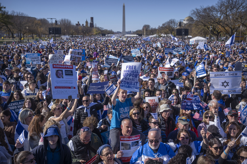 Participants hold signs as they stand on the National Mall at the March for Israel