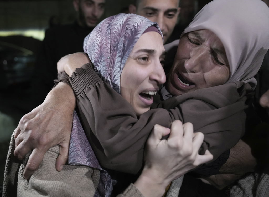 Shuruq Dwayat, left, a Palestinian prisoner released by Israel, is hugged by relatives as she arrives home in the east Jerusalem neighborhood of Sur Bahar