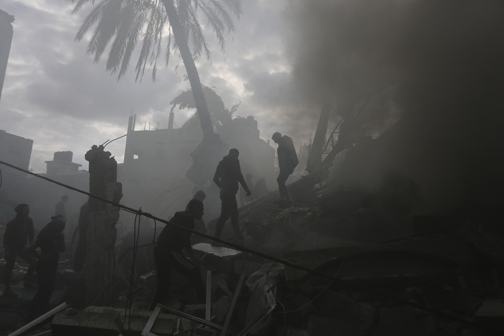 Palestinians look for the survivors of an Israeli strike in Rafah, Gaza Strip