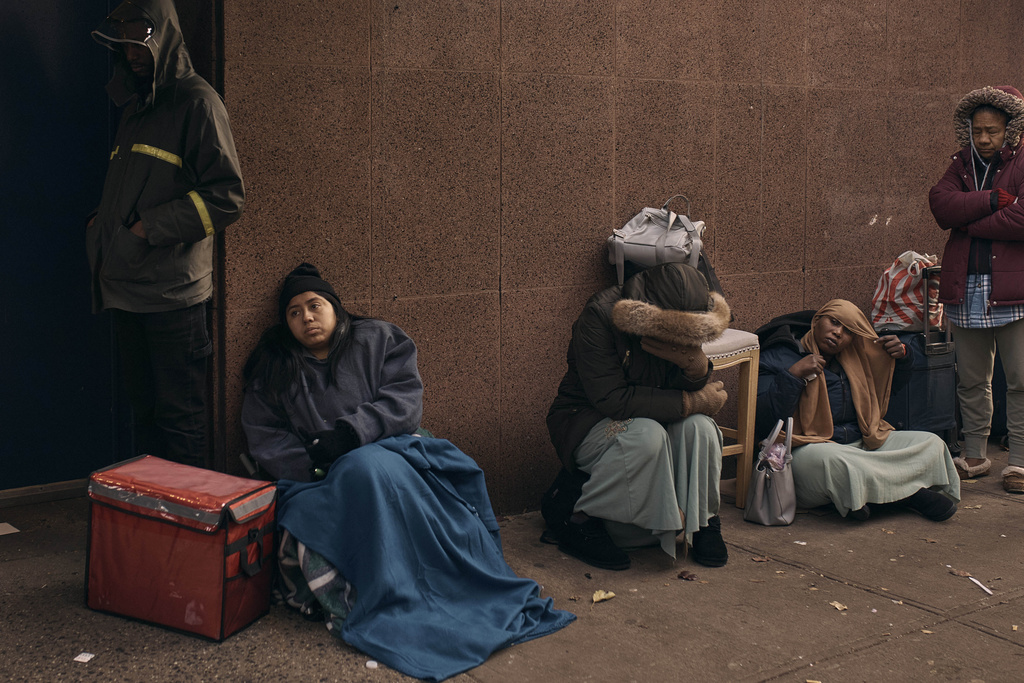 Migrants queue in the cold as they look for a shelter outside a migrant assistance center