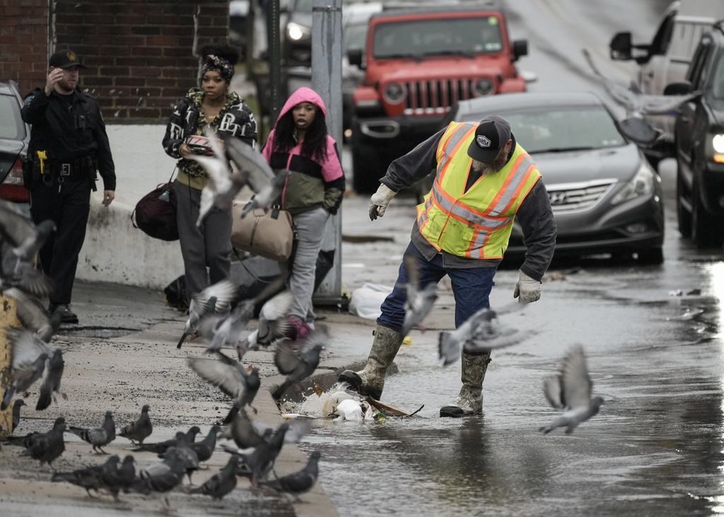 A worker clears debris from a storm drain in Collingdale, Pa.