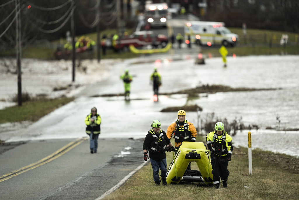 First responders move to put away their equipment after a person stranded by the floodwaters of the Perkiomen Creek near Graterford Road in Collegeville, Pa.