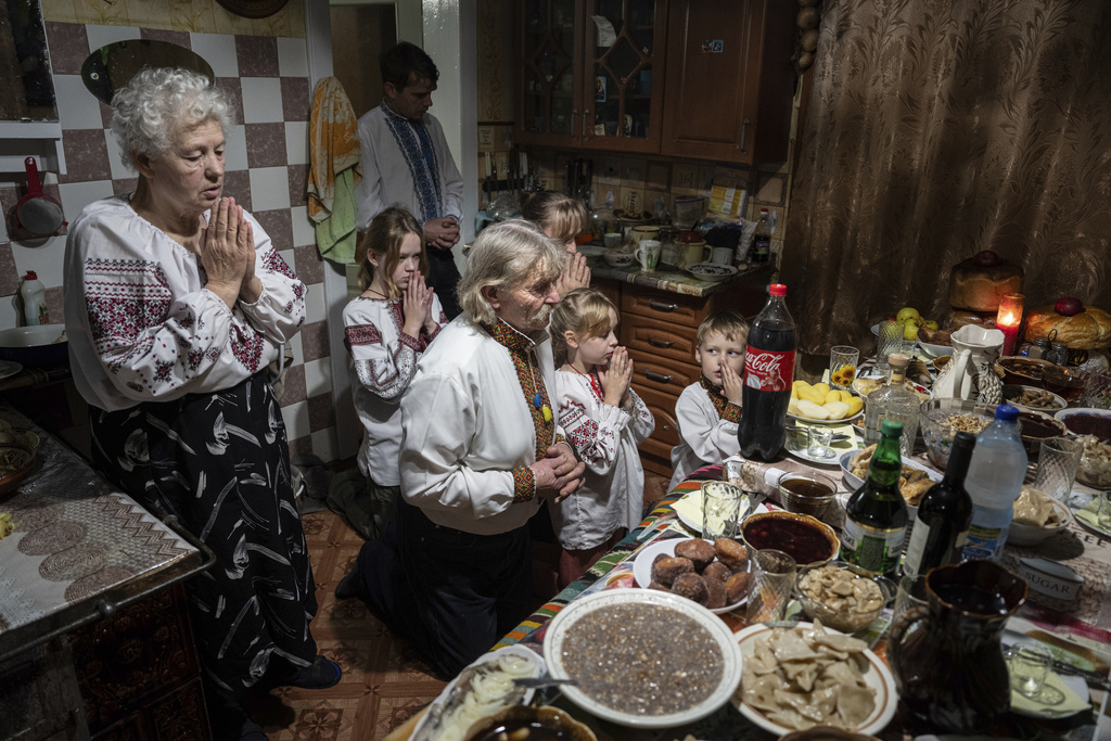 The Zelenchuk family prays before a Christmas dinner in Kryvorivnia village, Ukraine