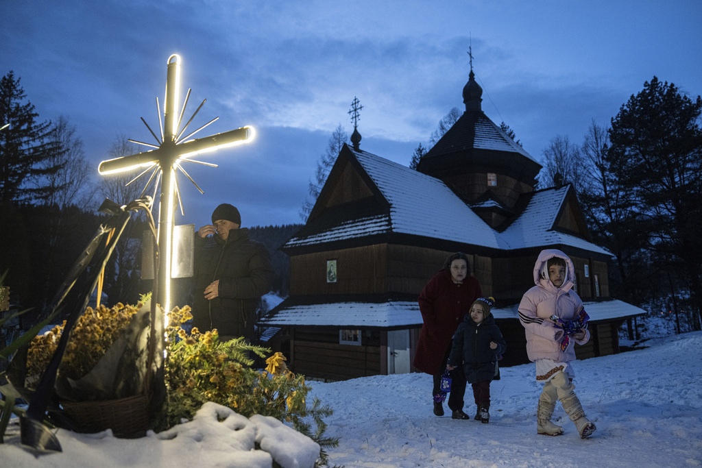 A woman with her children walk after church Christmas service in Kryvorivnia village, Ukraine