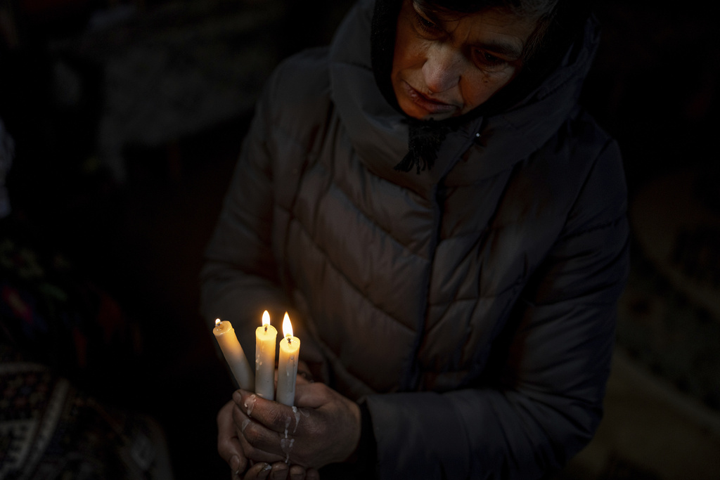 A woman prays inside the church during Christmas celebration in Kryvorivnia village, Ukraine