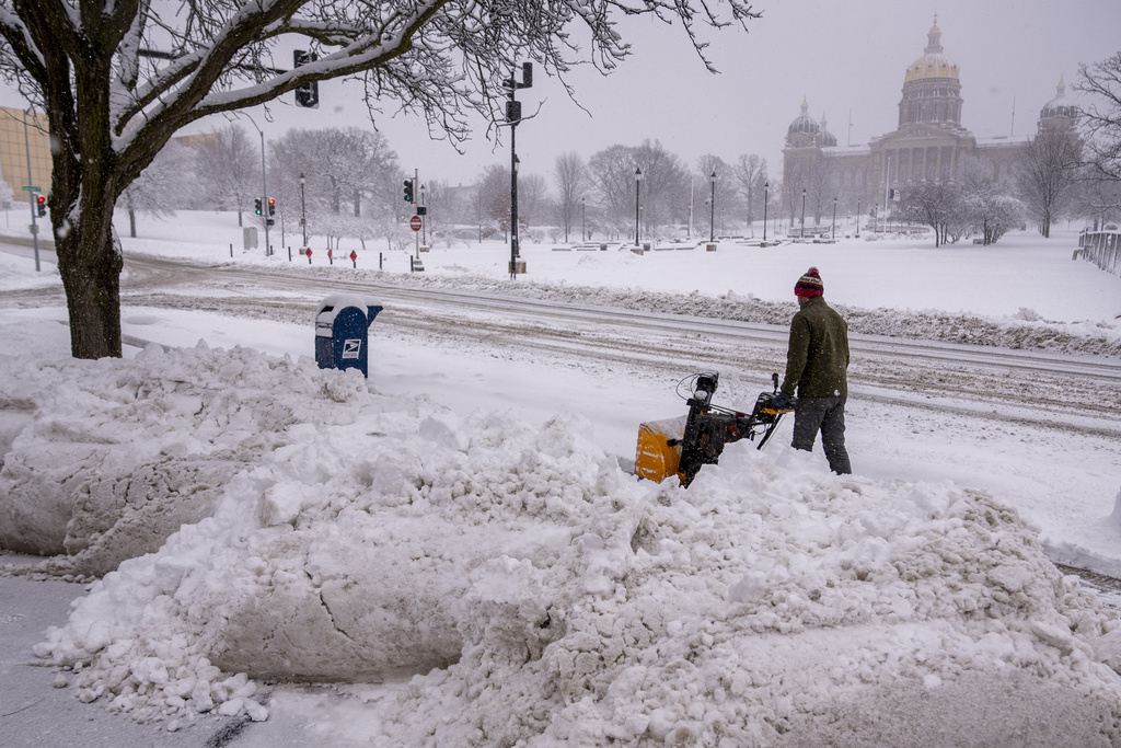 Person plows sidewalk near Iowa State Capitol Building