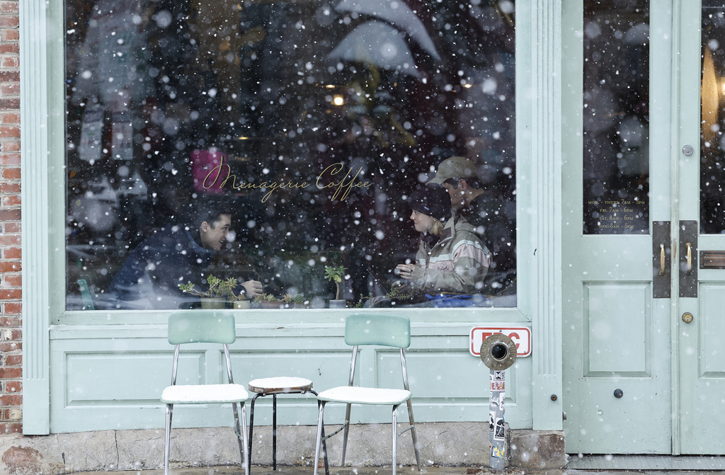 Customers sit inside a cafe as snow falls in the Old City neighborhood of Philadelphia 