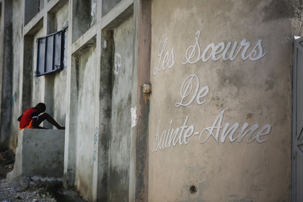 A young boy rests in front of the entrance of the Sisters of Saint-Anne residence in Port-au-Prince, Haiti, Monday, Jan. 22, 2024.