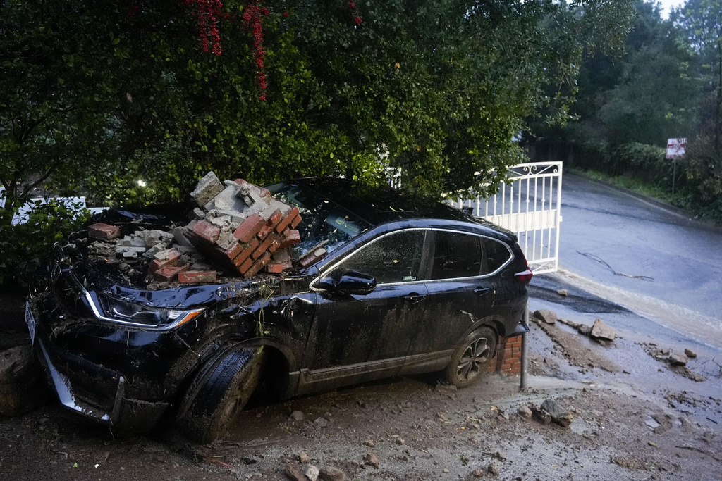 Car is damaged by debris from a storm in Studio City, Calif.