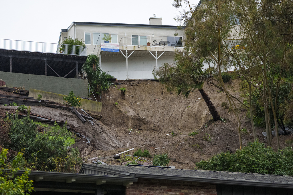 A mudslide scarred hillside in the backyard of a home