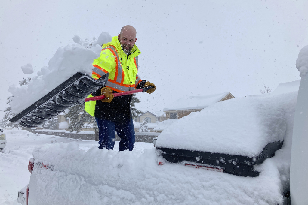 Man unloads snow from a truck bed