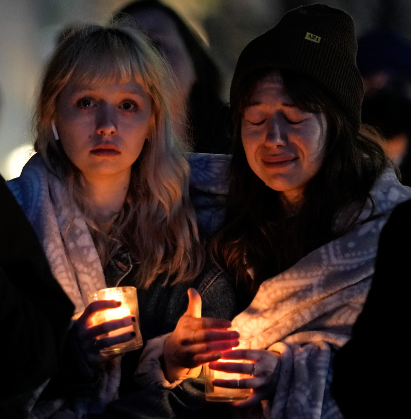 Abbie Lewis, left, and Jackie Batista-Martinez attend a candlelight vigil 