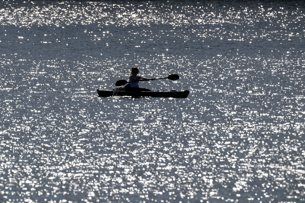 A woman takes advantage of unseasonably warm weather to kayak on Smithville Lake near Paradise, Mo.