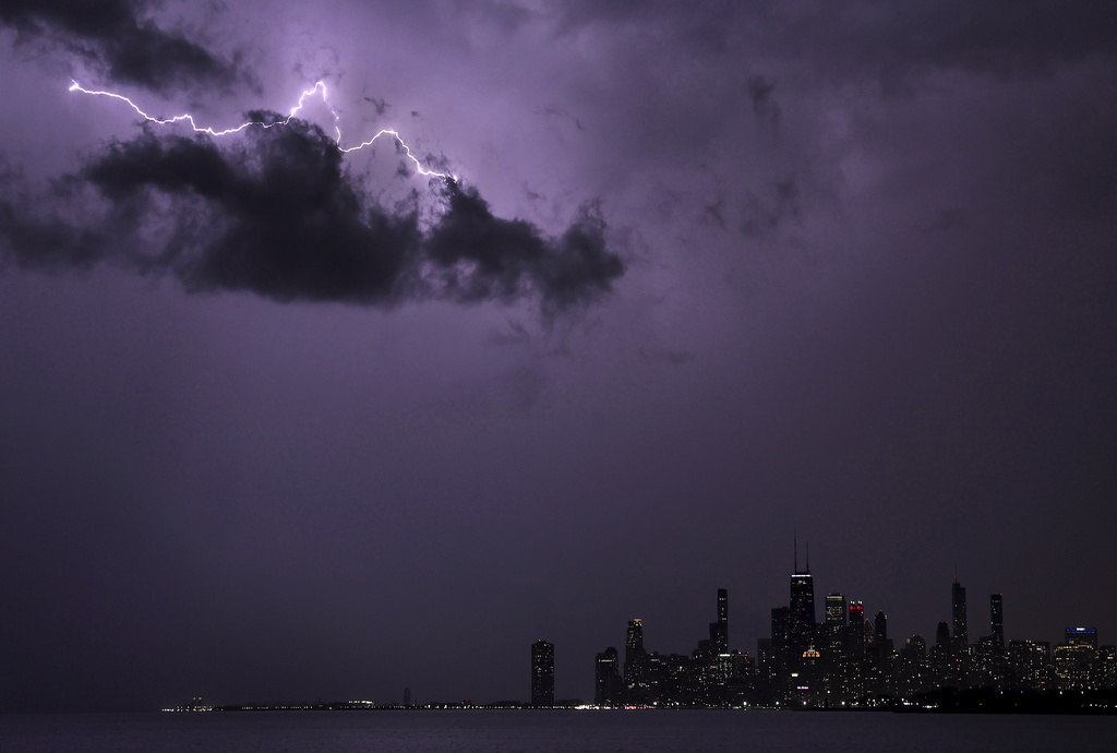 Lightning strikes above downtown Chicago as a storm moves over Lake Michigan following two days of unseasonably warm weather