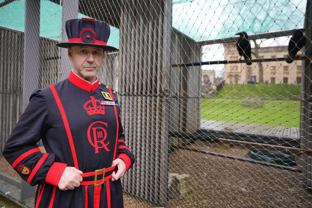 Barney Chandler, newly appointed ravenmaster stands alongside some ravens at The Tower of London in London