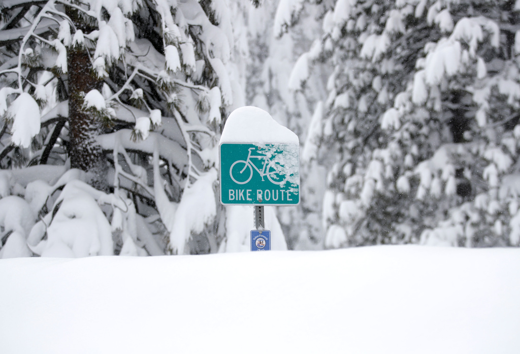 Bike sign is buried in deep snow along Highway 89 outside of Tahoe City, Calif.