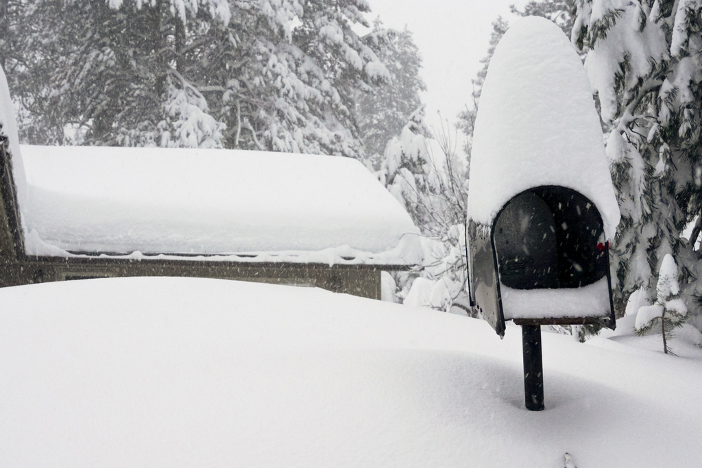 Mailbox and the roof of a home are covered in snow during a storm in Truckee, Calif. 