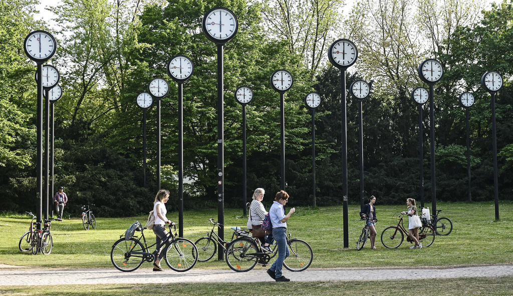 People with bicycles meet at the clock park