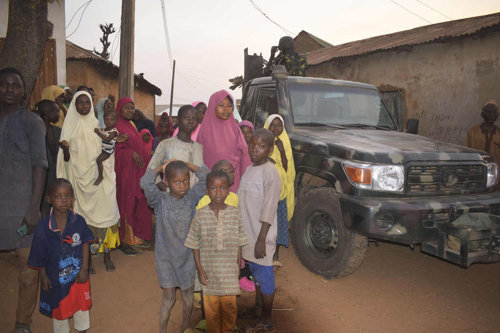 People gather around an area were gunmen kidnapped school children in Chikun, Nigeria