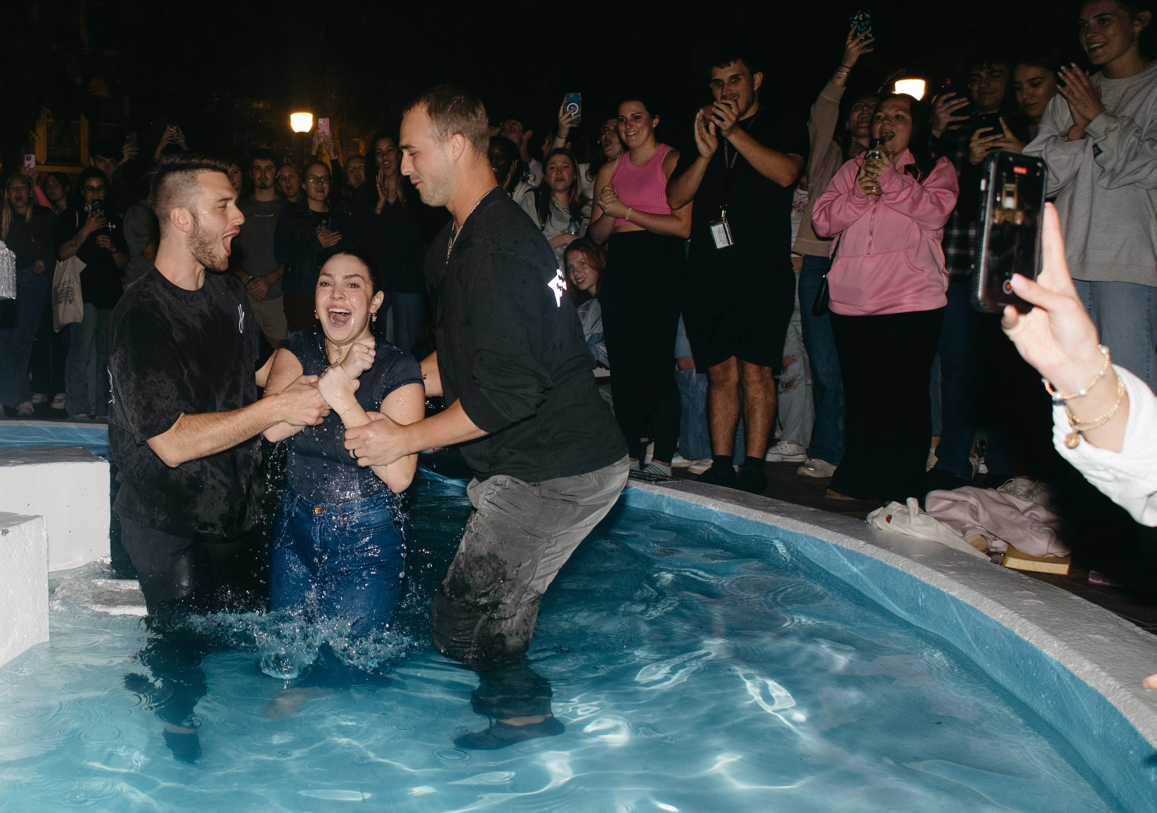 Young woman being baptized by two men
