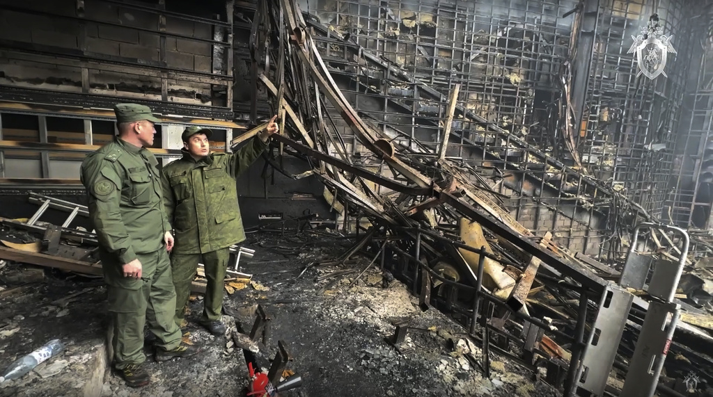 Investigators from the Investigative Committee of Russia examine the burned concert hall after an attack on the building of the Crocus City Hall on the western edge of Moscow