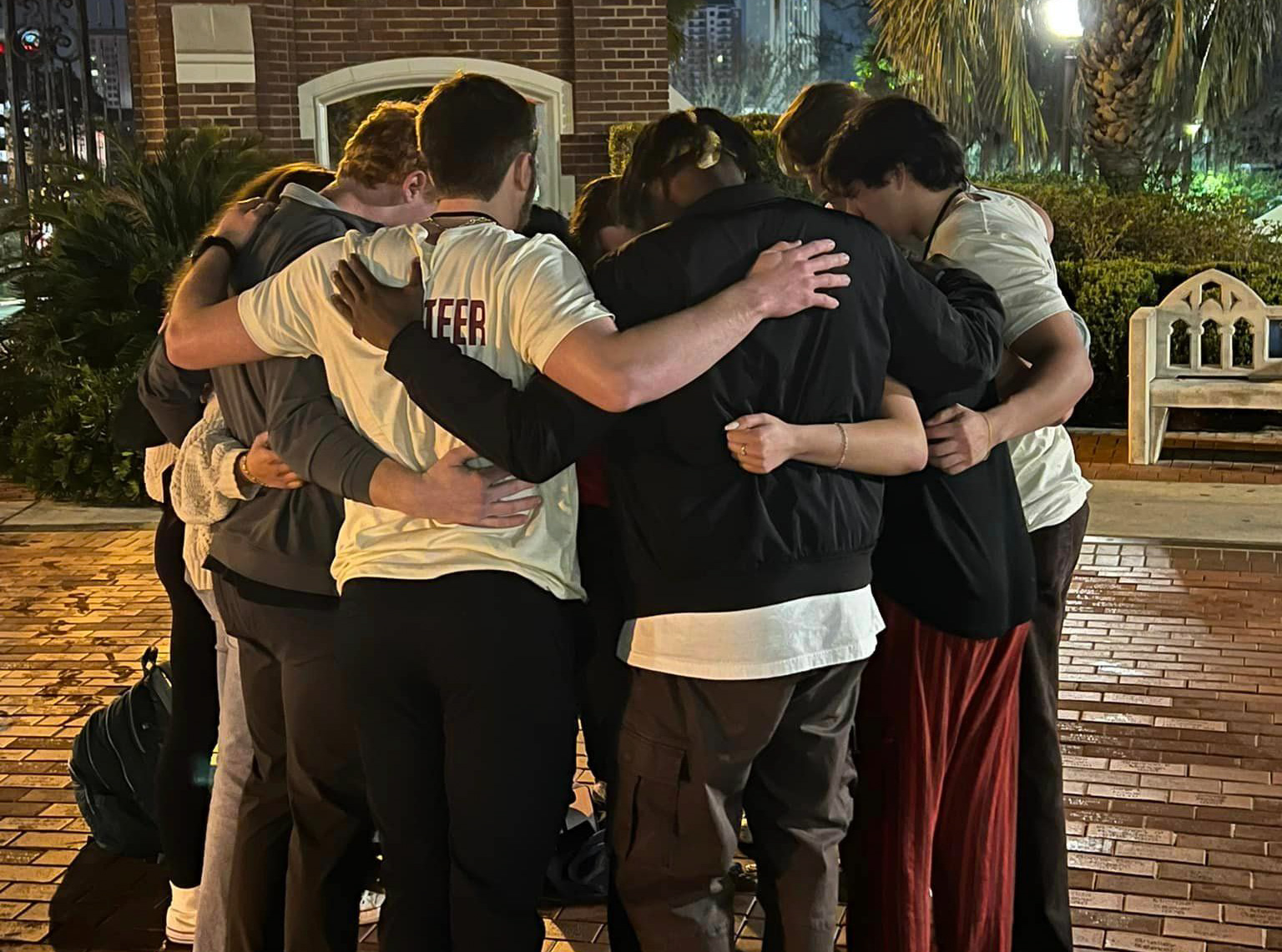 Young men huddled in prayer