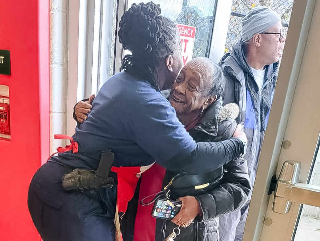 Female police officer hugging elderly woman