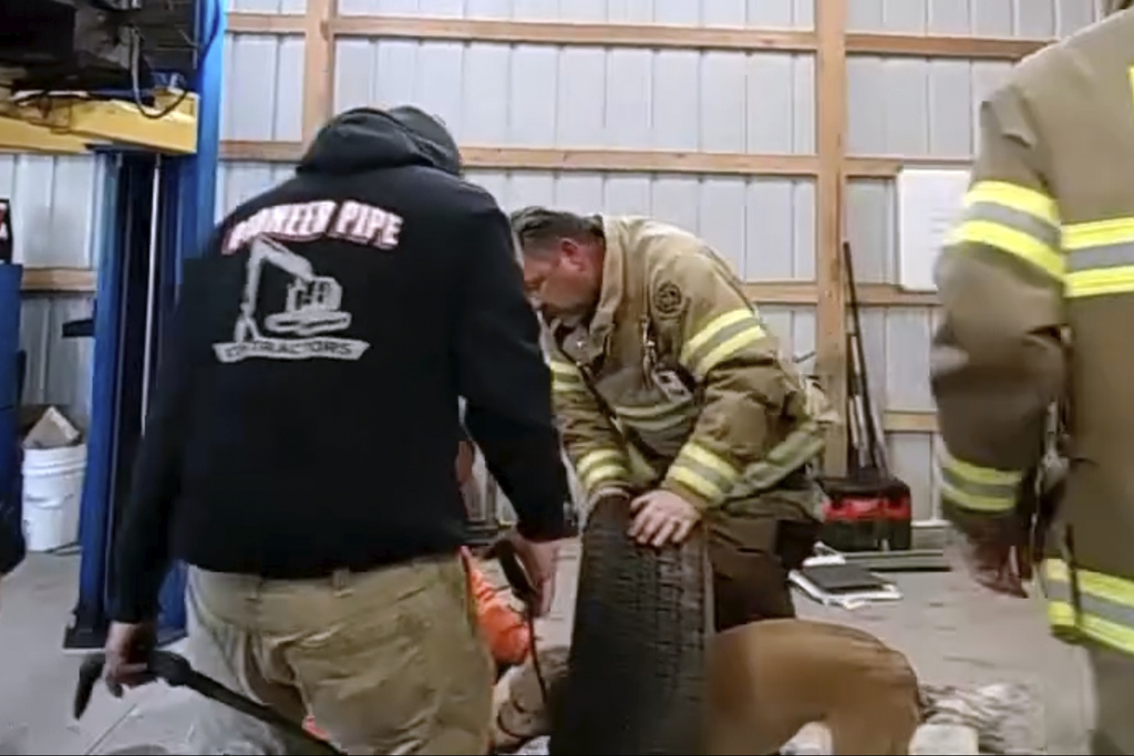 Franklinville Volunteer Fire Company members try to remove a dog who got stuck in the middle of the tire rim