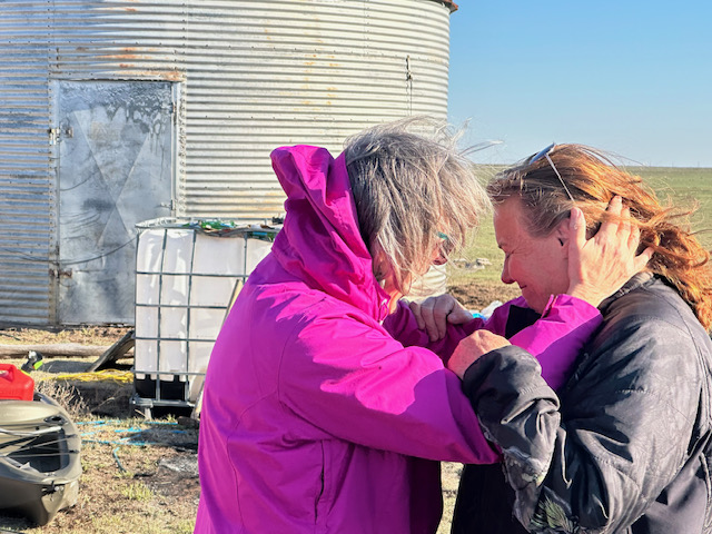 Women embrace after wildfires