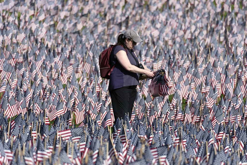 A volunteer tends to the sea of flags on Boston Common. The flags are placed ahead of Memorial Day to honor each service member from Massachusetts who has given their life for the United State since the American Revolution.