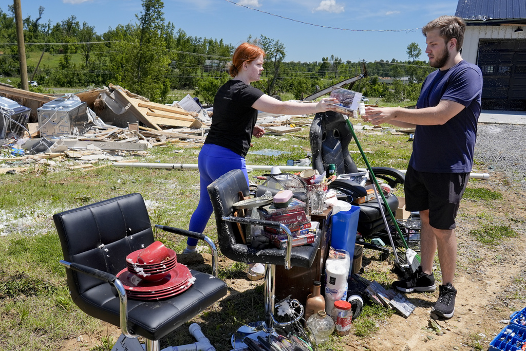 Victims collect their belongings from storm debris