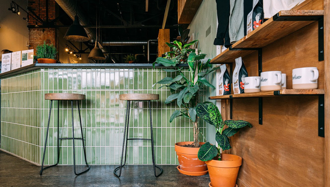 Coffee shop with two stools and green tile and coffee mugs