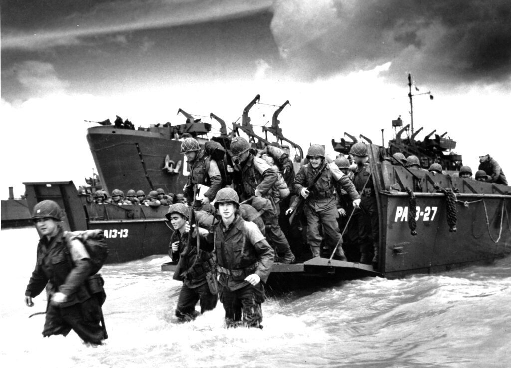 American reinforcements, arrive on the beaches of Normandy from a Coast Guard landing barge into the surf on the French coast 