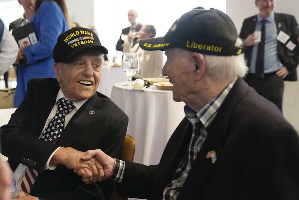 World War II veterans Andy Negra, left, and Hilbert Margol, speak to each other during an an event honoring the two