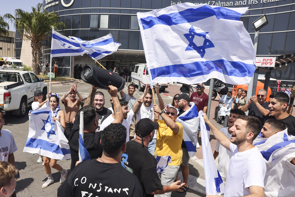 People wave Israeli flags as they celebrate after hostages who were kidnapped in a Hamas-led attack on Oct. 7. were rescued from Gaza Strip