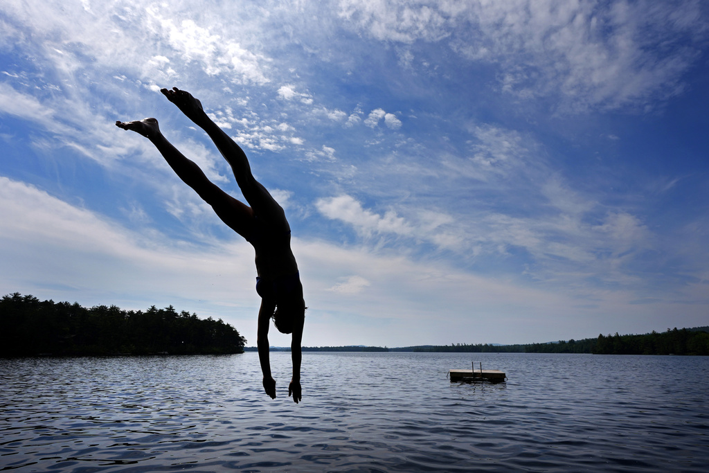 Melana Price, of Southfield, Mich., dives into Squam Lake at Rockywold Deephaven Camps, Thursday, June 20, 2024, in Holderness, N.H.
