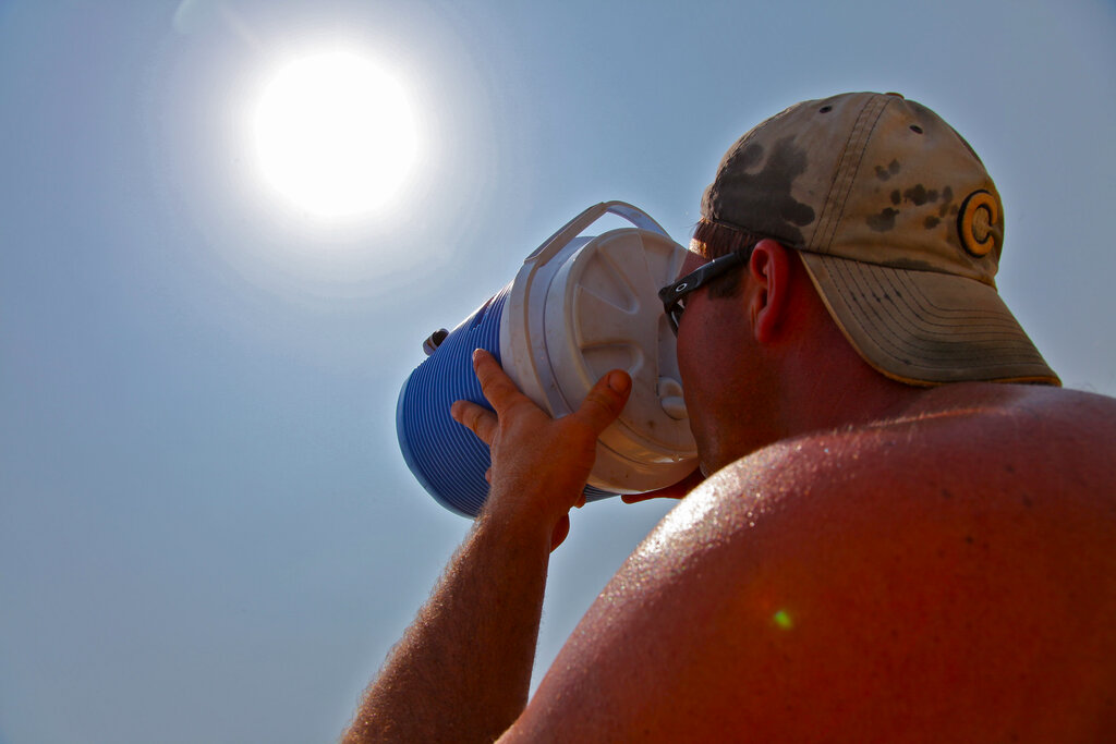 John Rohlfing, 38, takes a drink as he works on the construction of his new home