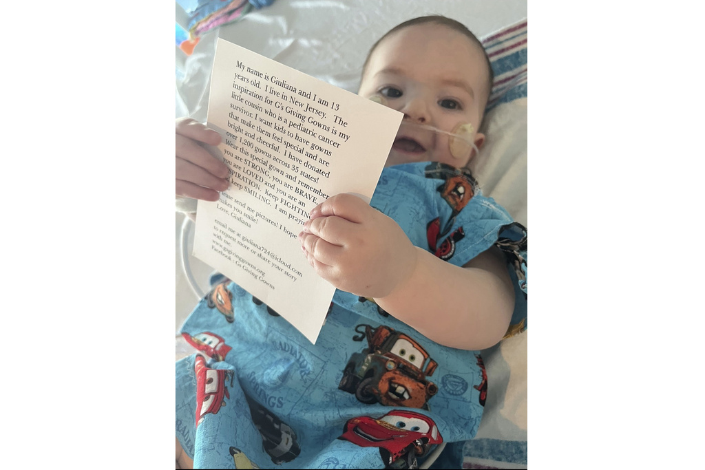 1-year-old Vito holds a card that came with the special hospital gown he was given at a NY hospital. The gown was made by two New Jersey sisters who have sewn and donated 1,800 brightly-colored and kid-themed hospital gowns to sick children.