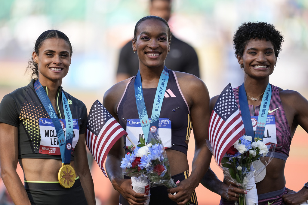 First place winner Sydney McLaughlin-Levrone, left, second place Anna Cockrell, right, and third place Jasmine Jones pose fopr a photo after the women