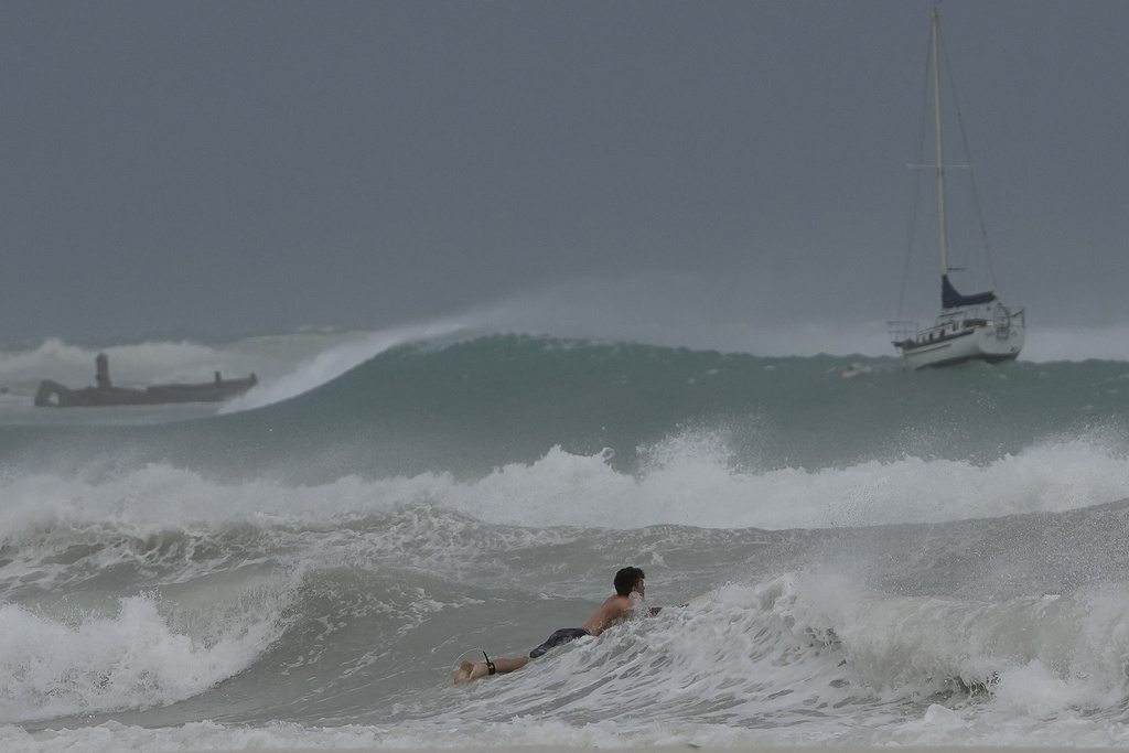 A unwise surfer braves the waves in Carlisle Bay as Hurricane Beryl passes through Bridgetown, Barbados