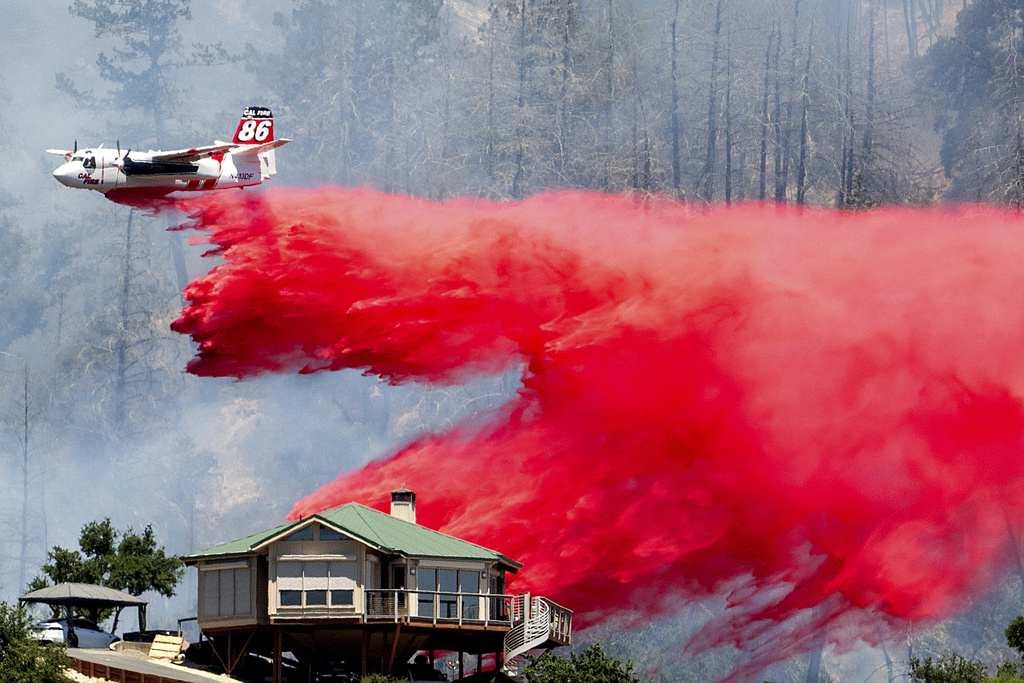 An air tanker drops retardant behind a home while battling the Toll Fire near Calistoga, Calif.