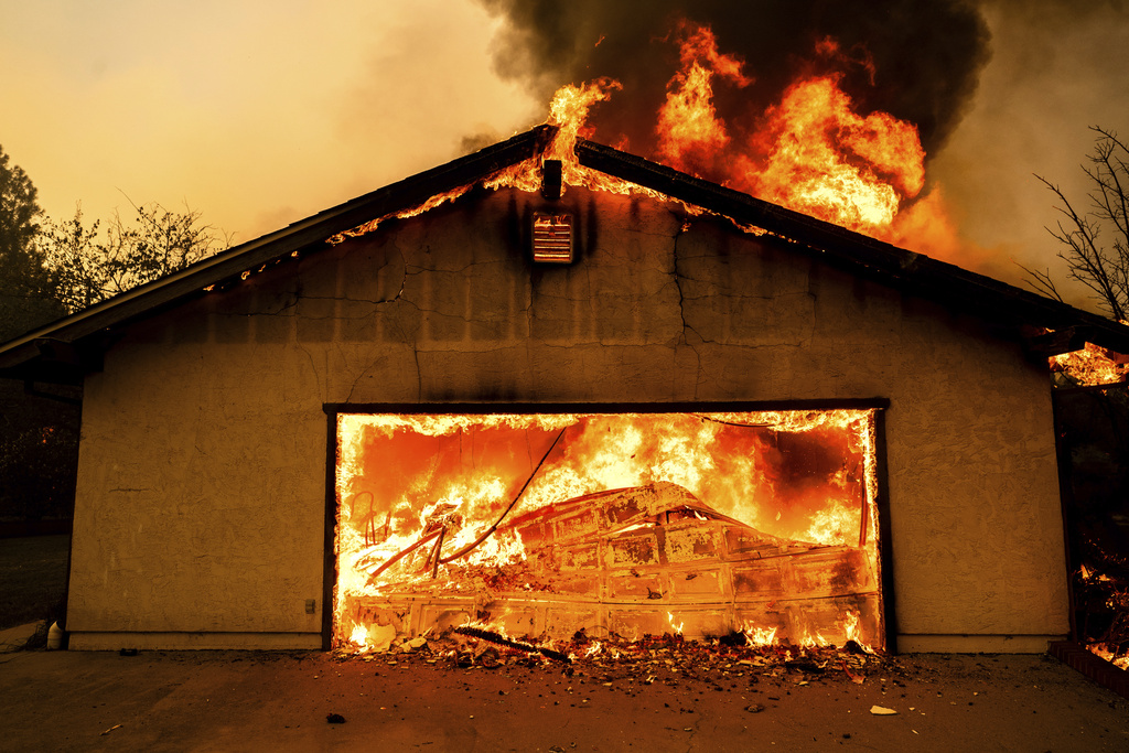 Flames consume a garage as the Thompson Fire burns in Oroville, Calif.