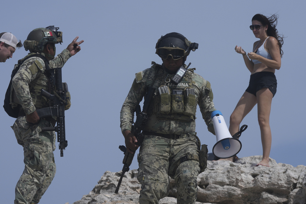 Soldiers ask a tourist to evacuate Mirador beach ahead of Hurricane Beryl